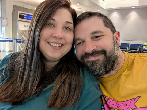 chuck and ashley squeezing in the pre-flight selfie at the United gates in houston, all smiles before the twelve-ish hours of flying between them and tokyo kick in.