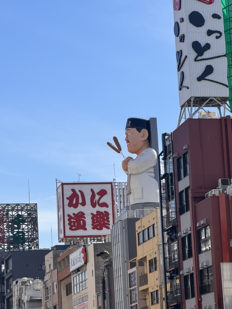 christina caught this iconic shot of the MASSIVE kani doraku crab sign in dotonbori - osaka's famous food district where giant 3d signs compete for attention