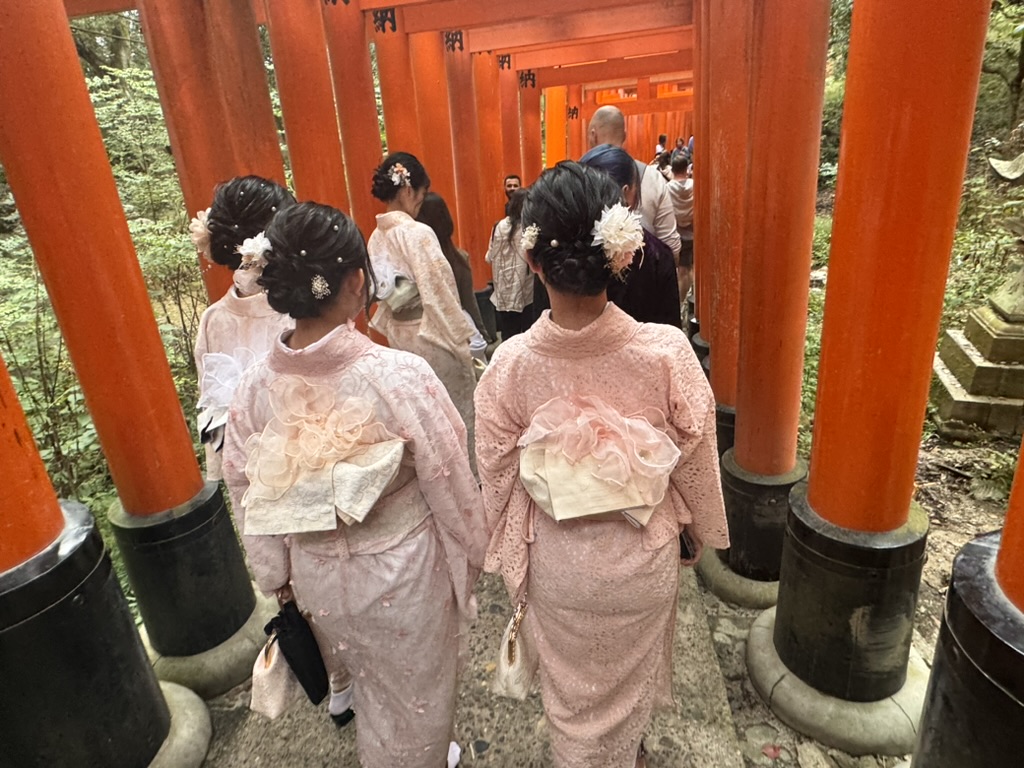 spotted these women in matching pink kimonos walking through the ICONIC torii gates at fushimi inari shrine. christina caught this perfect shot of their traditional obi bows.