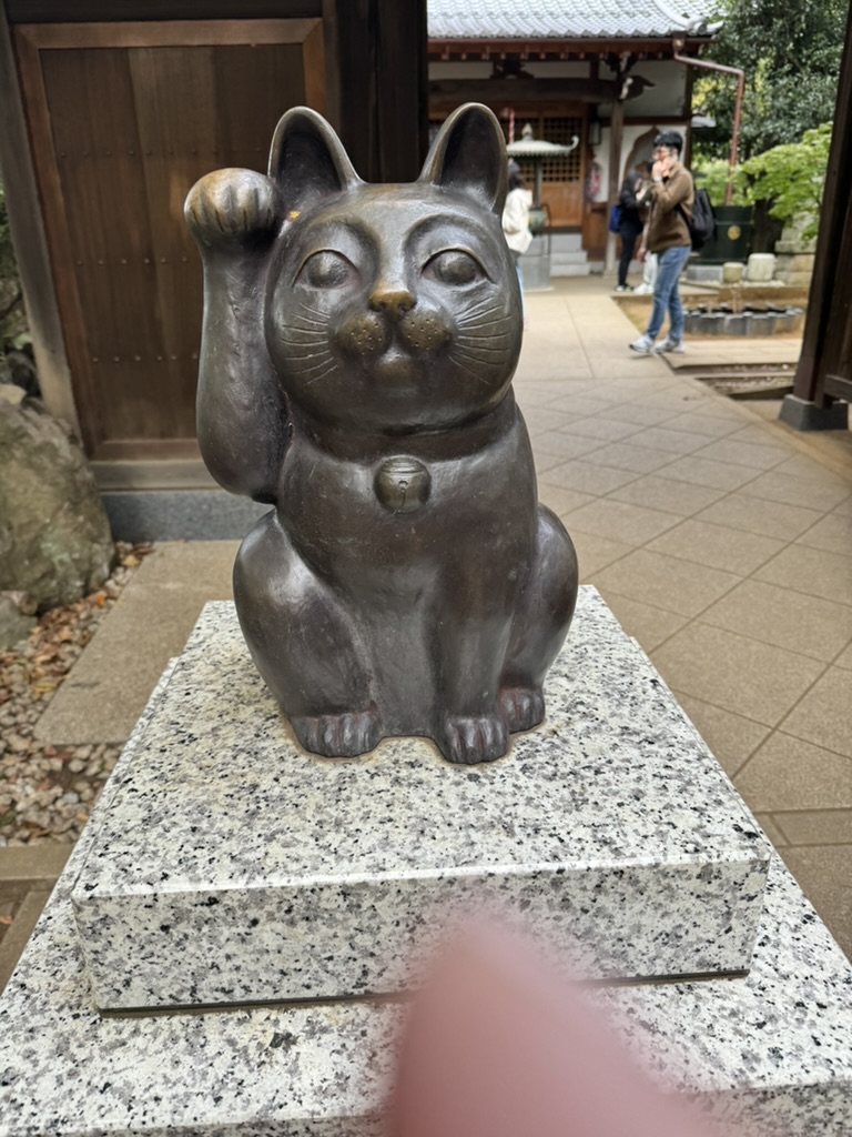 christina found this lucky maneki-neko statue at gotokuji temple, the ORIGINAL birthplace of japan's famous beckoning cats