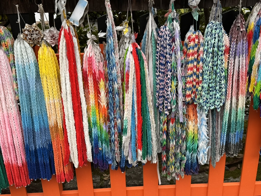 colorful paper cranes at fushimi inari shrine near kyoto. christina caught this shot of the senbazuru displays hanging along the path.