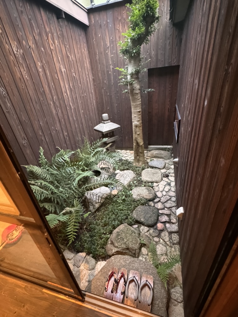 tiny zen garden at our osaka machiya, complete with the MOST aesthetic pair of geta by the door