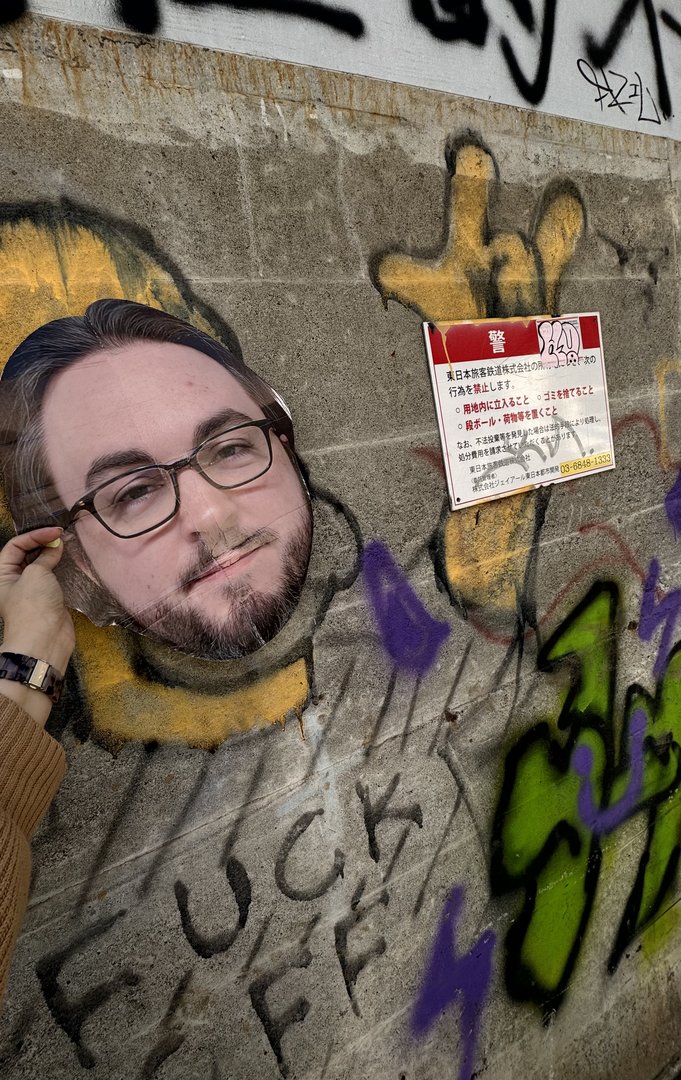 daniel found some street art in shinjuku that lets you stick your head through it. classic tourist move next to what appears to be a "no graffiti" sign