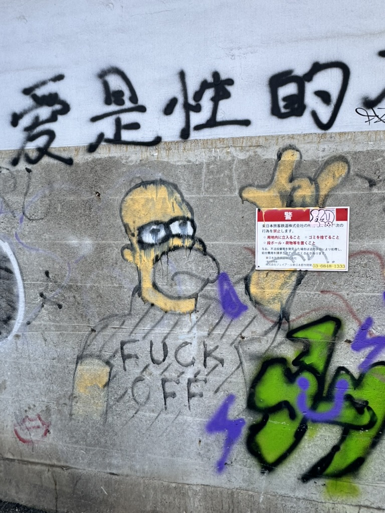 early morning walk through shinjuku with christina revealed this VERY out-of-place homer simpson graffiti next to some kanji