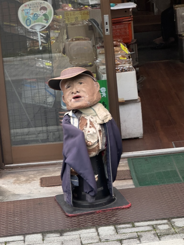 this quirky old man statue guards a shop entrance in kyoto's kamishichiken district - japan's oldest geisha district still has some WILD storefront decorations