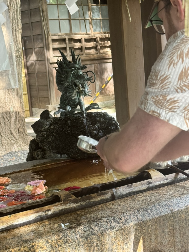 daniel performing the ritual cleansing at the chozuya fountain outside gotokuji temple, where we learned about the REAL origin of those lucky cat statues