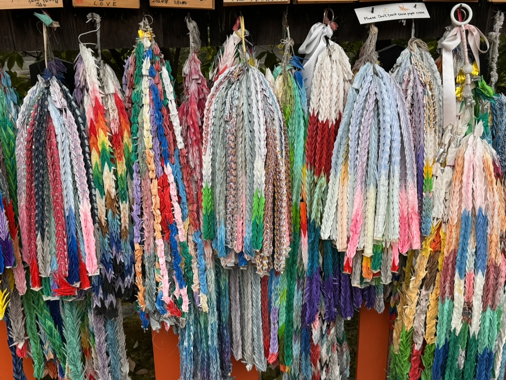 thousands of colorful paper cranes at fushimi inari shrine - christina caught this amazing display of senbazuru while we explored the shrine grounds