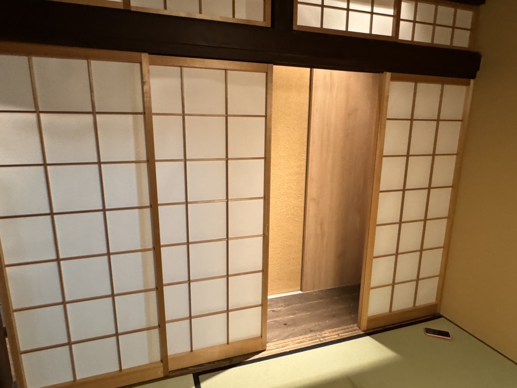 waking up to these GORGEOUS shoji screens in our traditional osaka house. christina's phone on the tatami mat for scale.