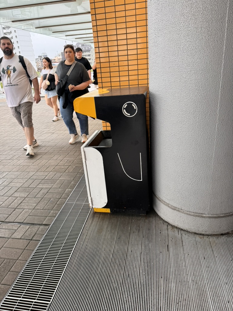 even the trash cans near osaka aquarium are designed to look like penguins. daniel and ashley walking ahead while checking out the kaiyukan area.