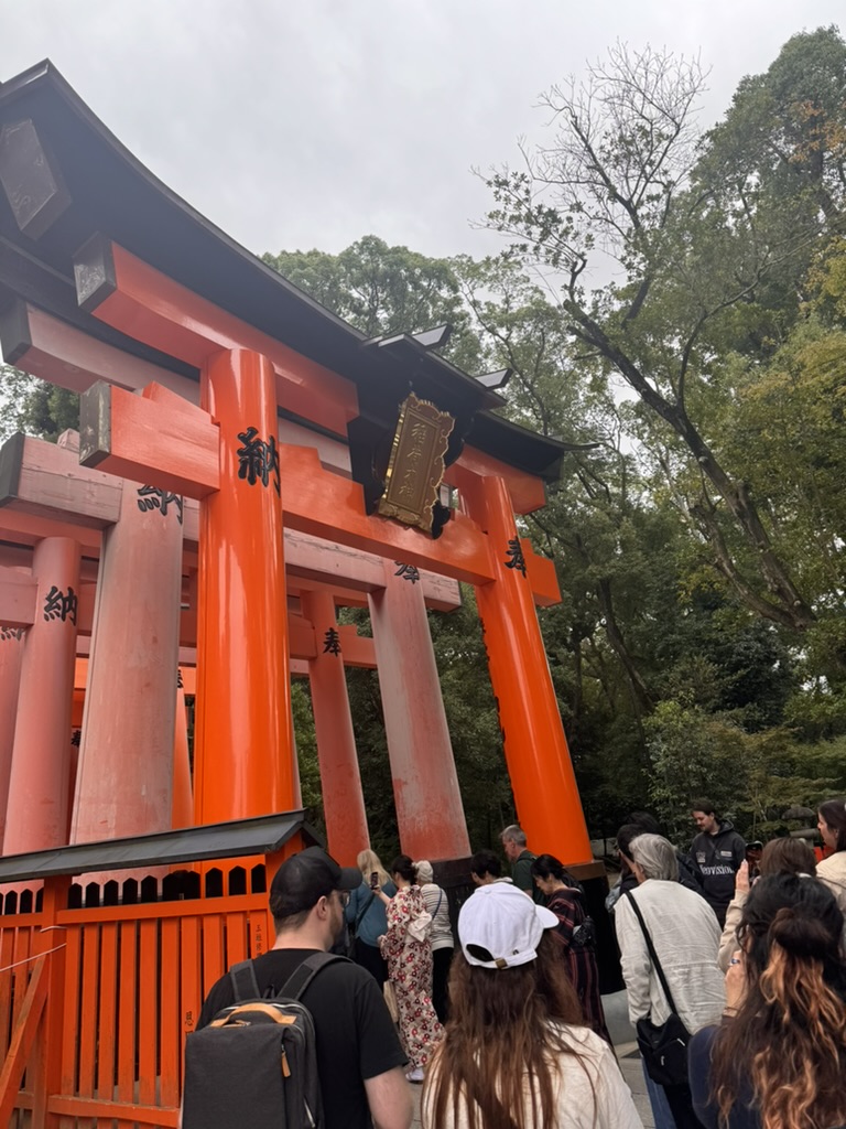 daniel and christina joining the crowd at the iconic torii gates of fushimi inari shrine on a cloudy kyoto morning