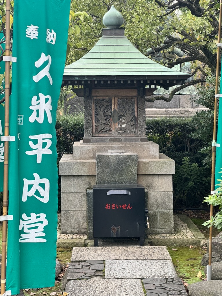 morning walk through taito led christina to this traditional ossuarium at sensoji temple, complete with japanese banner and ornate wooden carvings