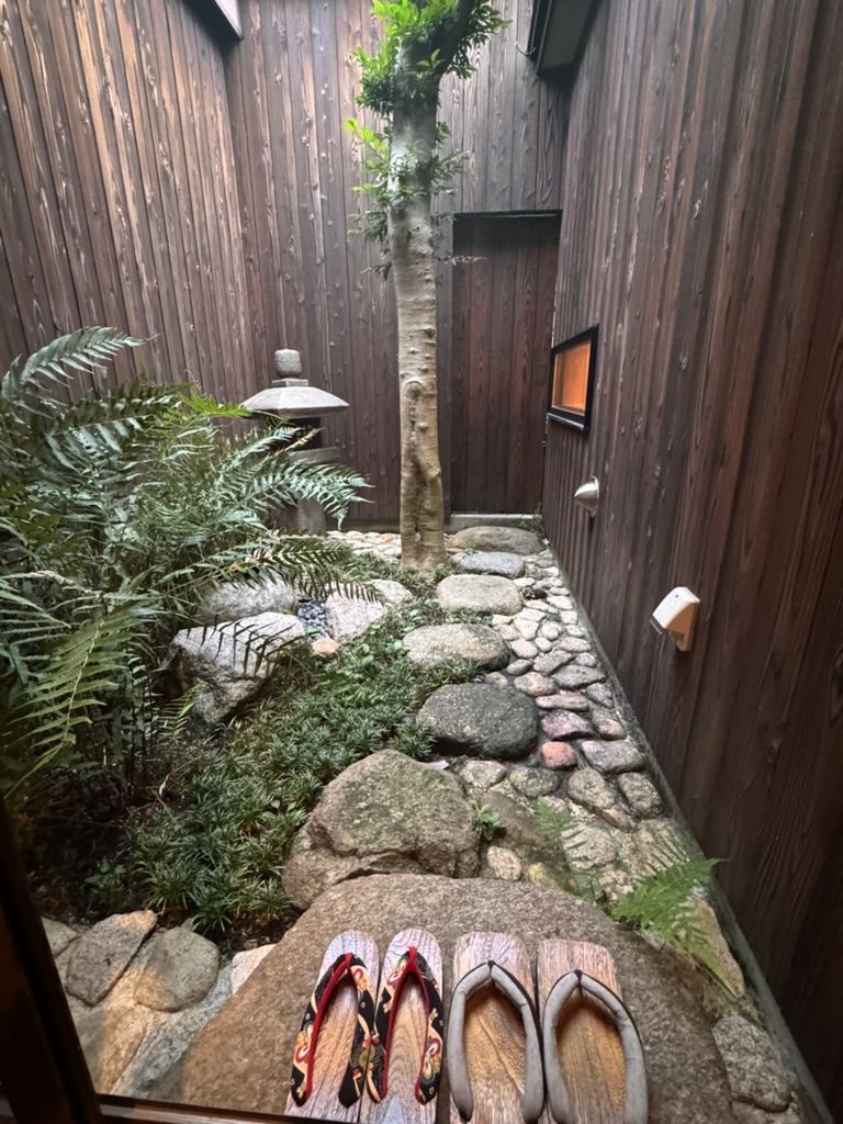 early morning peek at the tiny garden outside our traditional osaka house - dan and christina's slippers lined up just like the locals do