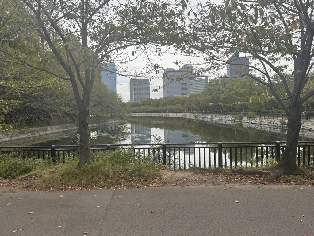 morning walk through osaka castle park - christina caught this quiet moment where the moat reflects the modern city beyond the historic grounds