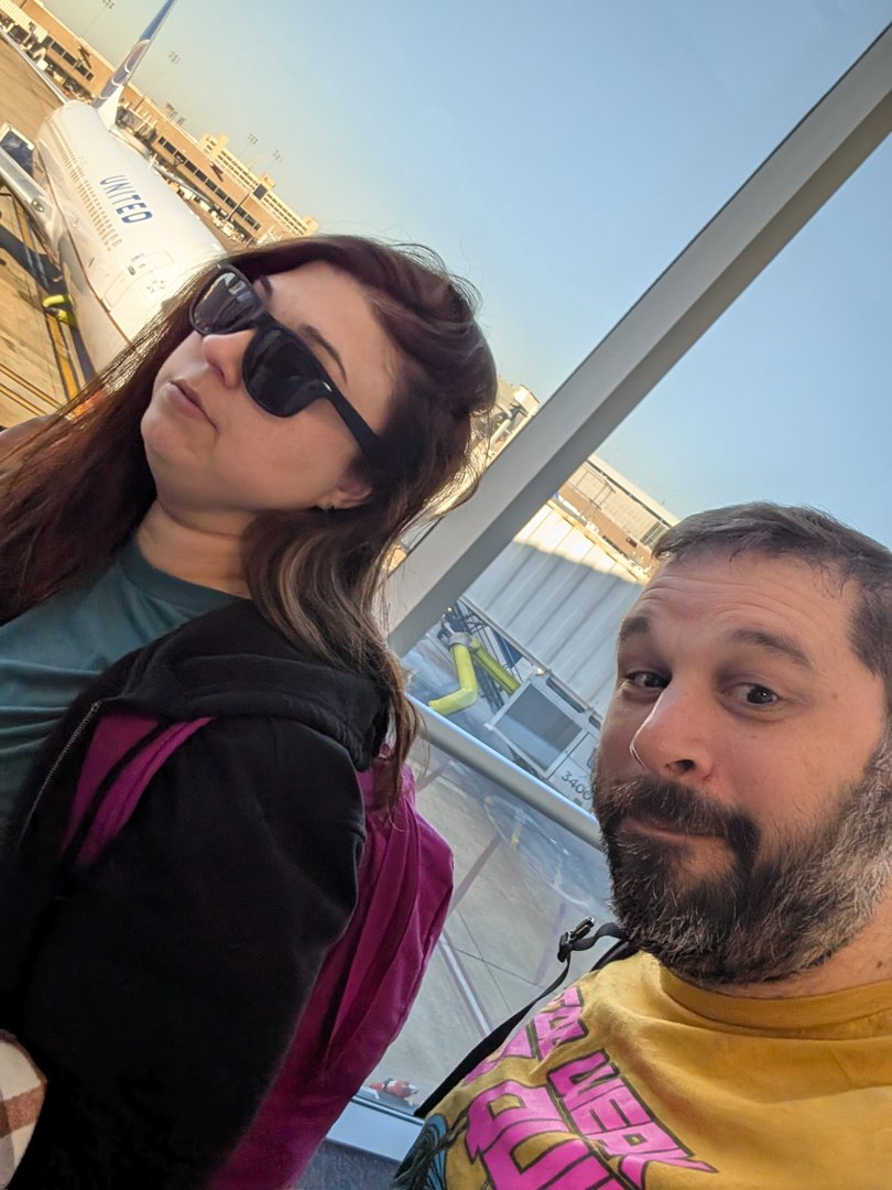 chuck and ashley at houston airport, ready to kick off their japan adventure. united airlines terminal selfie before the LONG flight across the pacific.