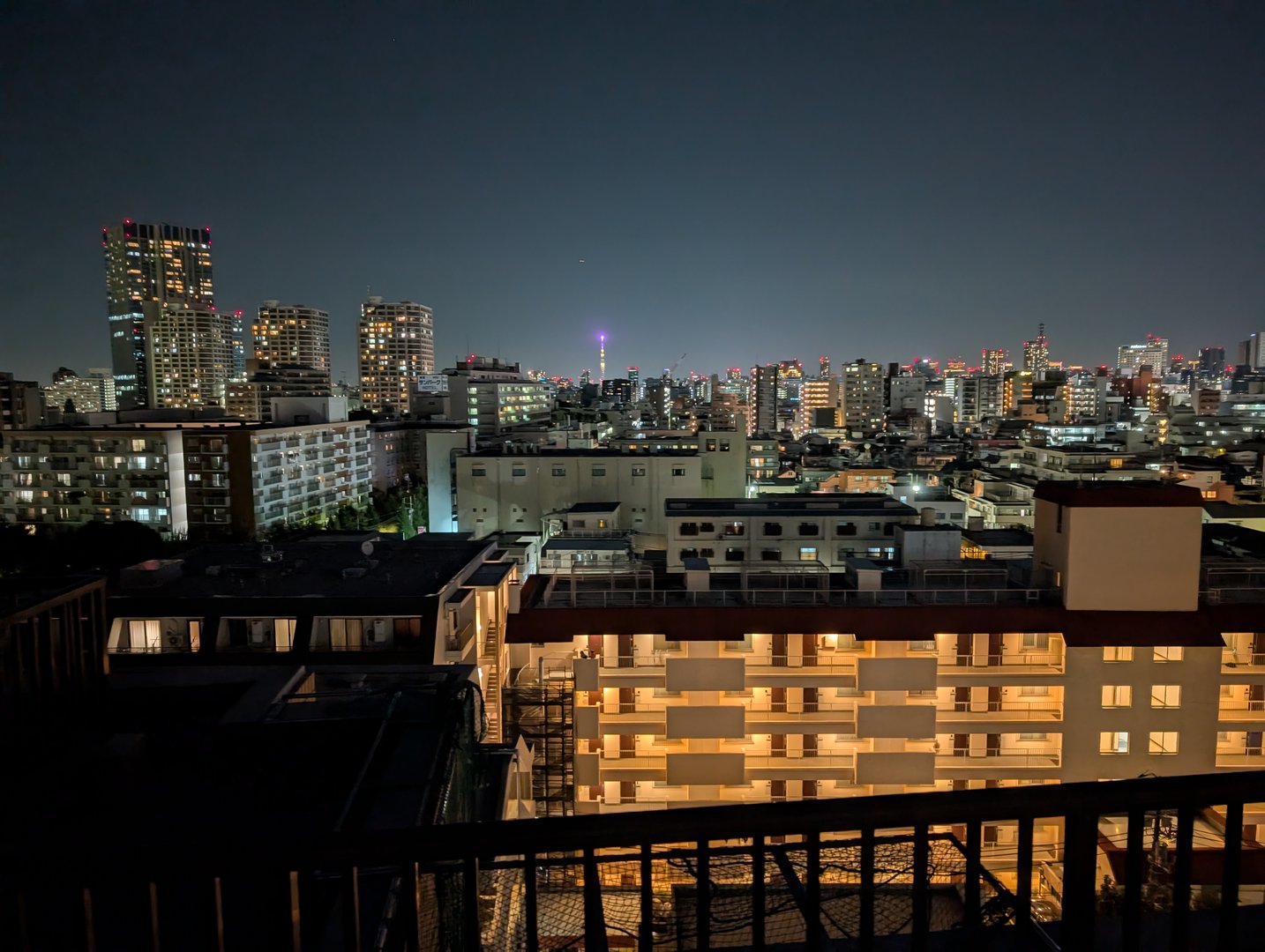 night view from our shinjuku airbnb balcony with tokyo tower glowing purple in the distance. chuck's first attempt at capturing tokyo's MASSIVE scale.