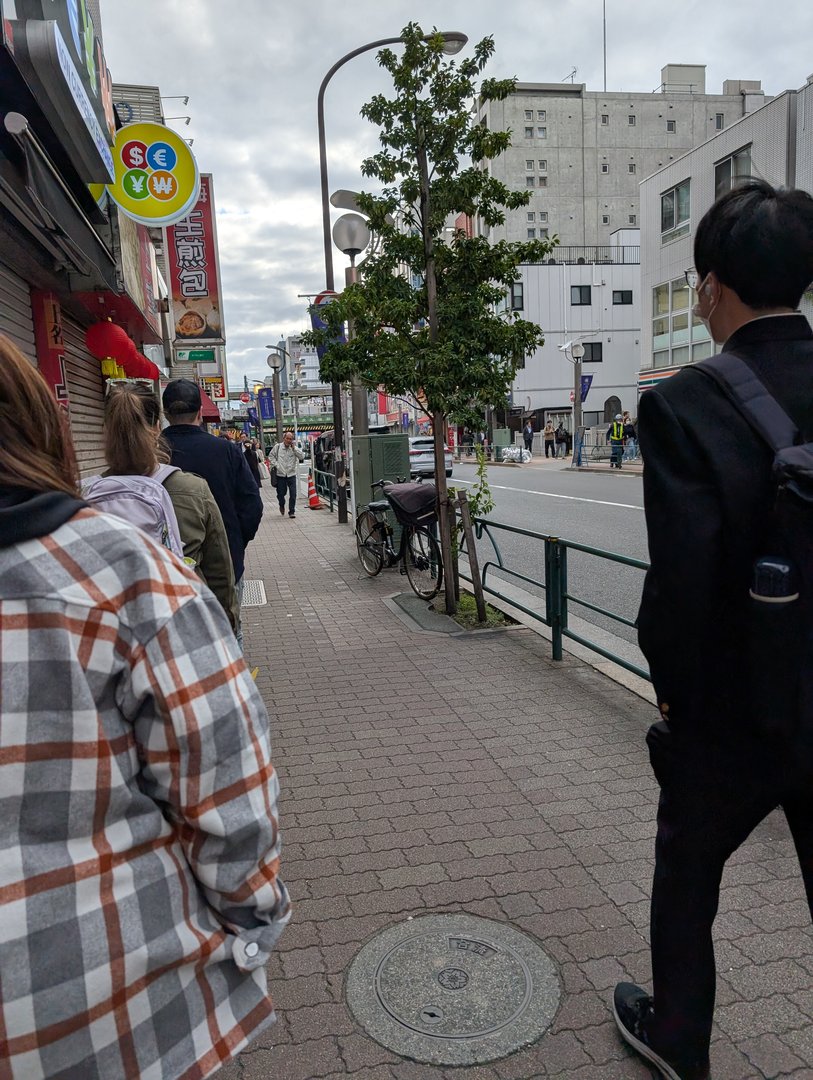 ashley and chuck waiting in line at 8am outside a currency exchange spot in shinjuku - turns out EVERYONE needs yen first thing in the morning