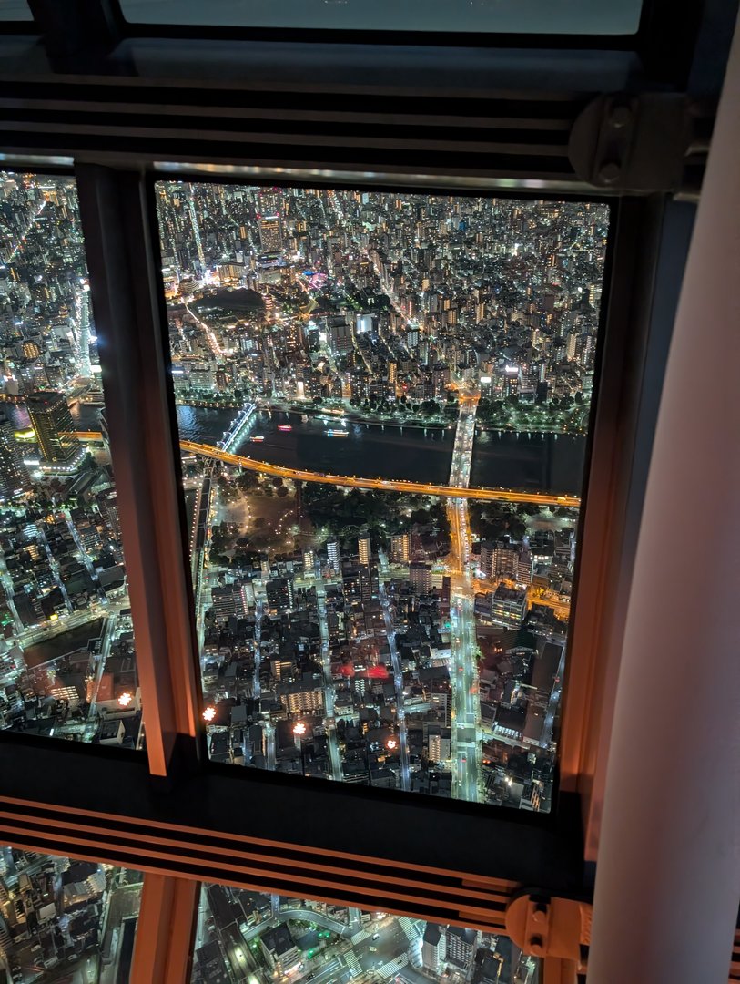 view from the TOKYO SKYTREE observation deck showing the sumida river cutting through the glowing cityscape at night. chuck managed to get this shot through the window without any reflections showing up.