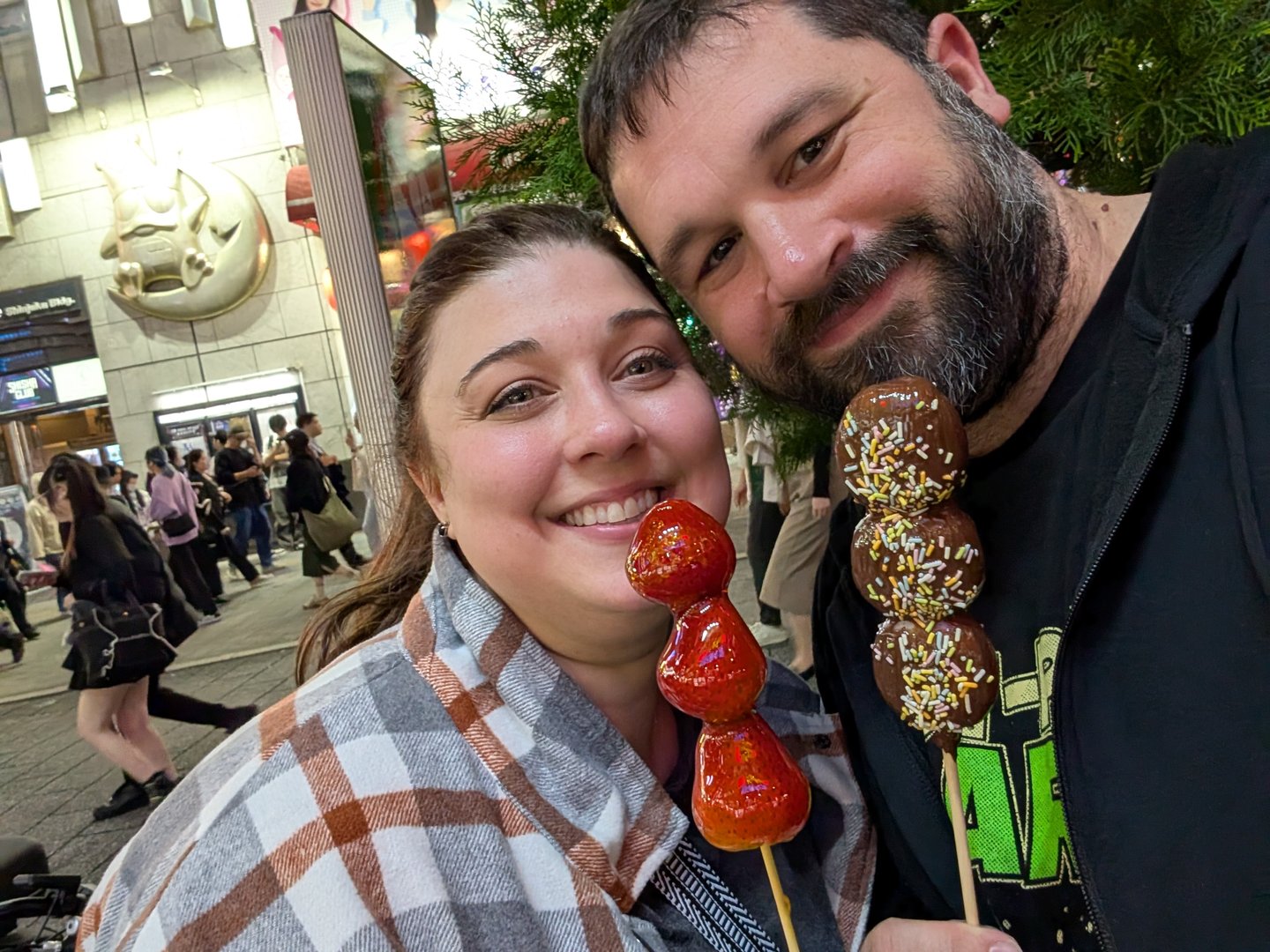 chuck and ashley trying different dango flavors while exploring shinjuku at night - strawberry for her, chocolate with sprinkles for him