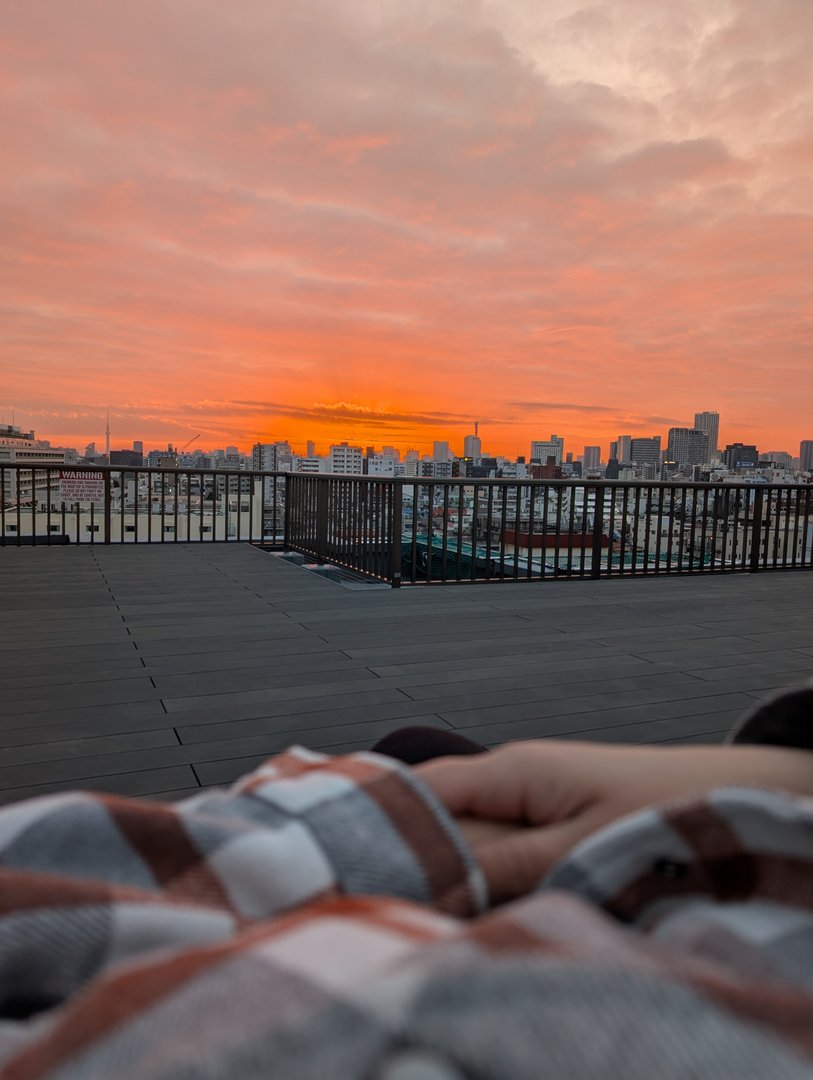 early morning blanket vibes with ashley on our airbnb rooftop in shinjuku. tokyo's skyline doing the MOST with this sunrise.