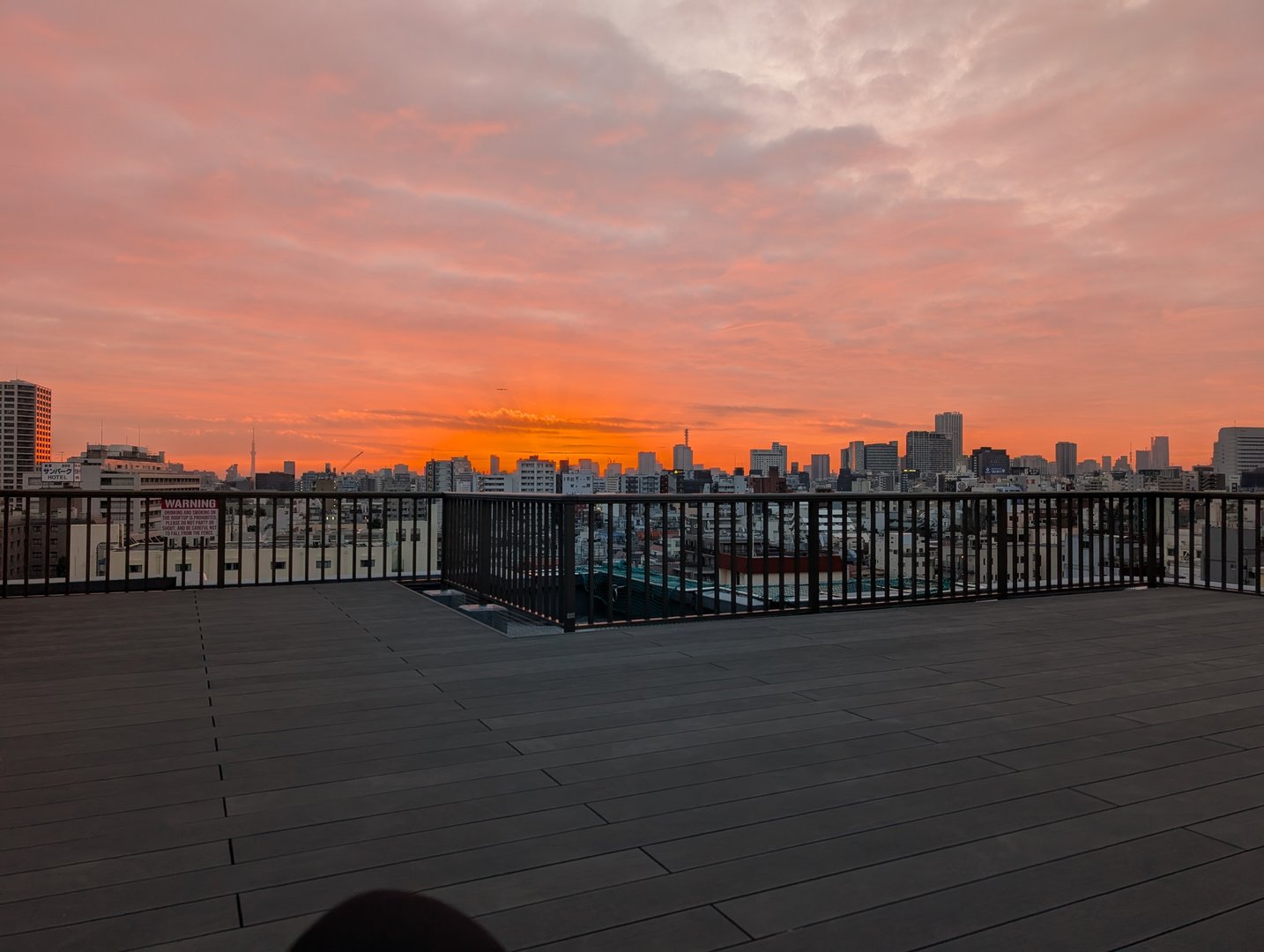 6am sunrise from our shinjuku airbnb rooftop - you can spot the SKYTREE in the distance through that wild orange sky