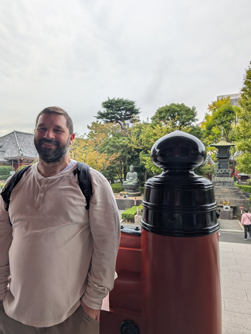 daniel at sensoji temple grounds, standing next to one of those MASSIVE red bollards they use to keep cars away from the temple steps