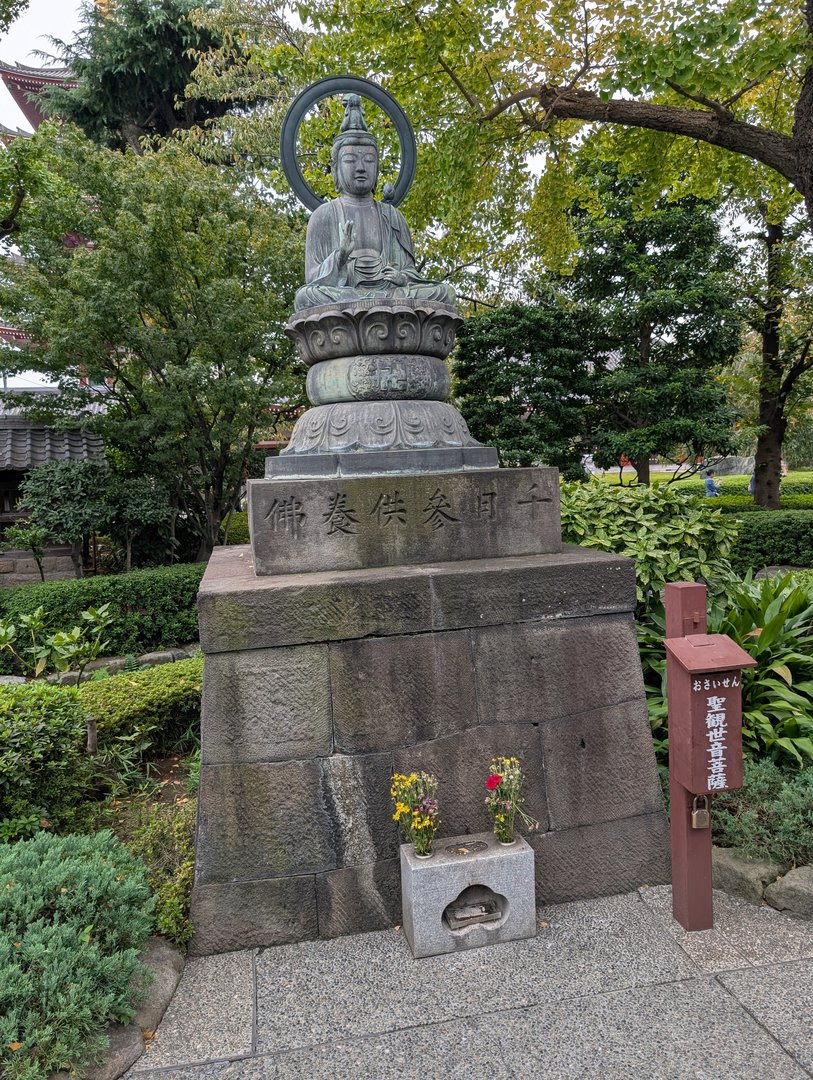 early morning wandering through the grounds of sensō-ji temple - chuck caught this peaceful buddha statue with fresh flowers at its base