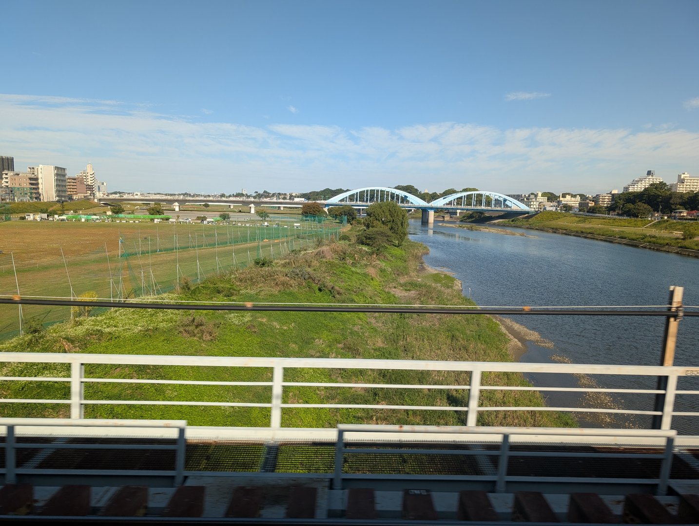 quick shot from the train window crossing the tama river - chuck caught this view of the iconic blue bridge while heading into tokyo from haneda airport