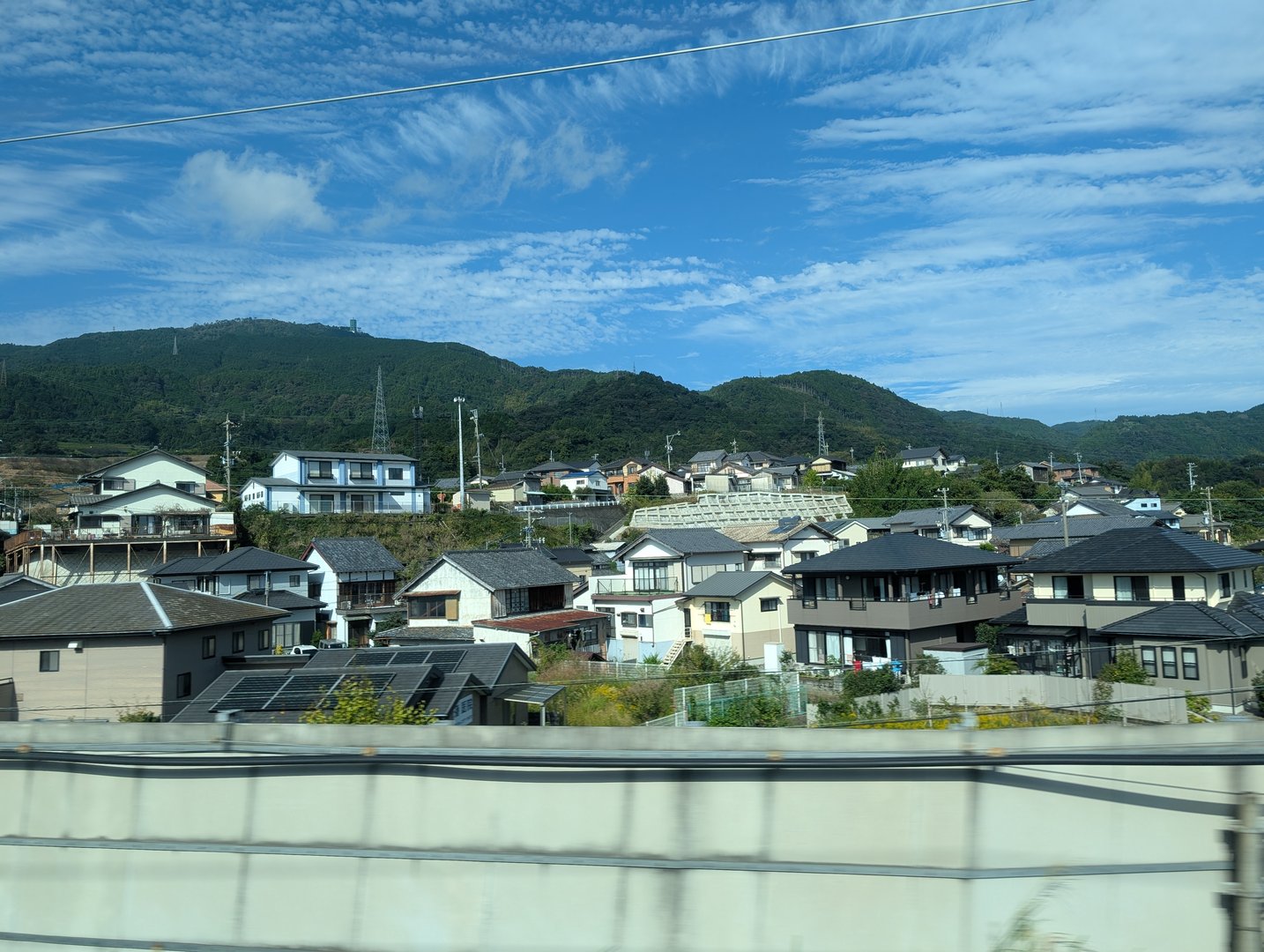 quick snap from the shinkansen window passing through fuji - love how these residential neighborhoods blend modern solar panels with traditional japanese architecture