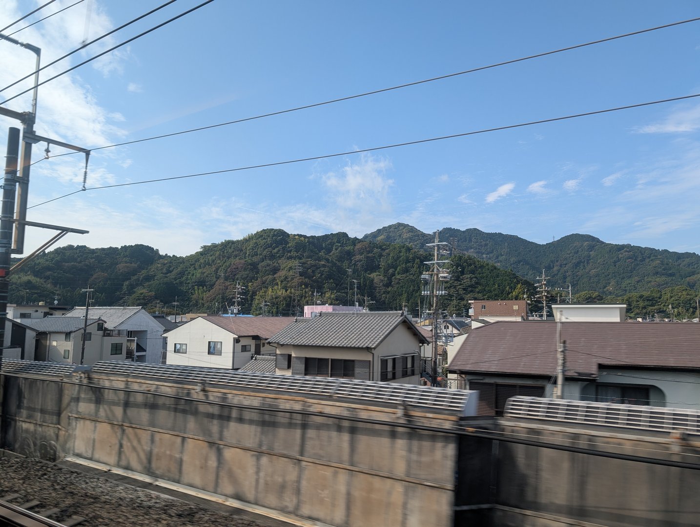 quick snap from the SHINKANSEN as we zoomed through shizuoka - those traditional roofs against the mountains are peak japan vibes