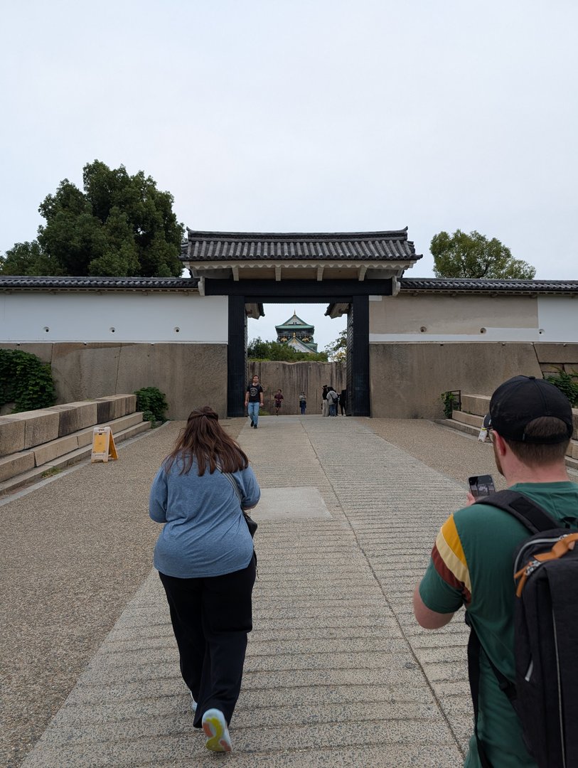 ashley and chuck approaching the otemon gate at osaka castle - you can just barely see the castle tower peeking through