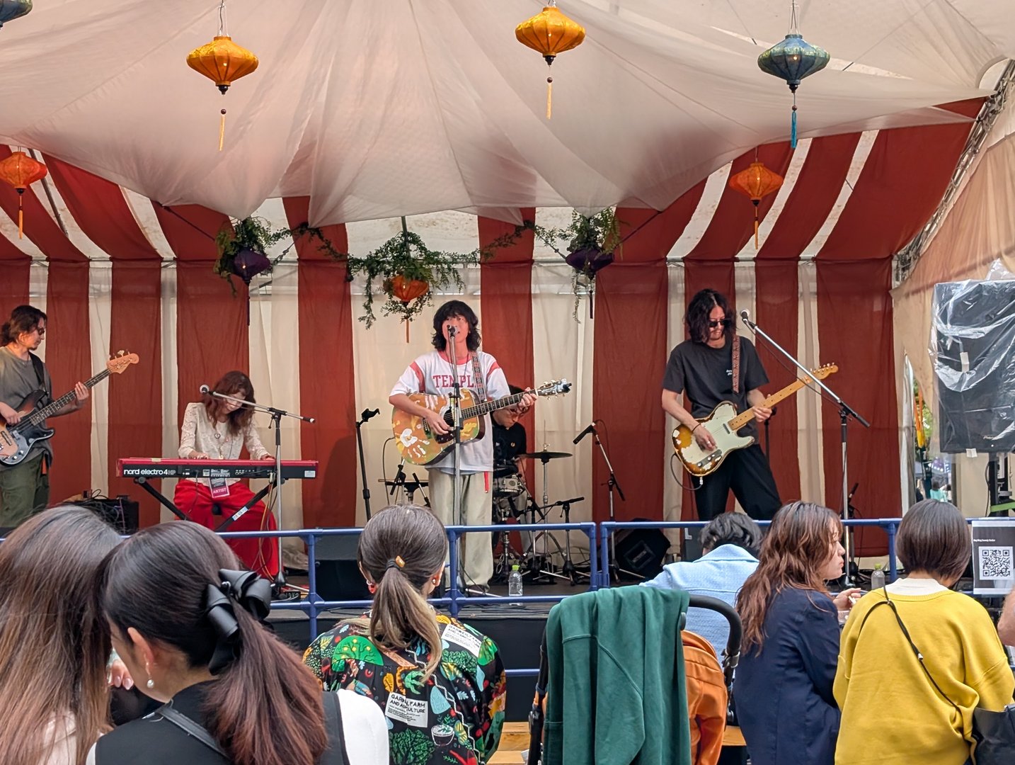 stumbled onto this indie band playing at a street festival near shibuya - total j-rock vibes with those paper lanterns and red striped tent