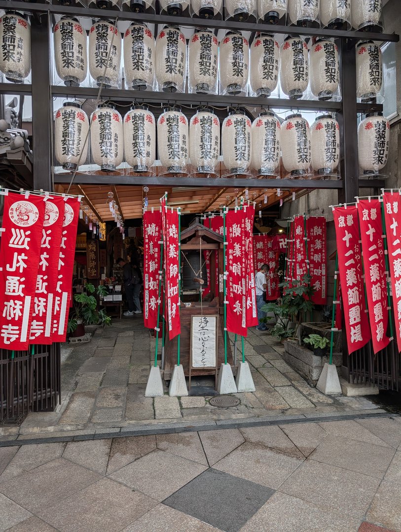 stumbled onto this AMAZING shrine entrance near nishiki market - those paper lanterns and red banners are giving major kyoto vibes