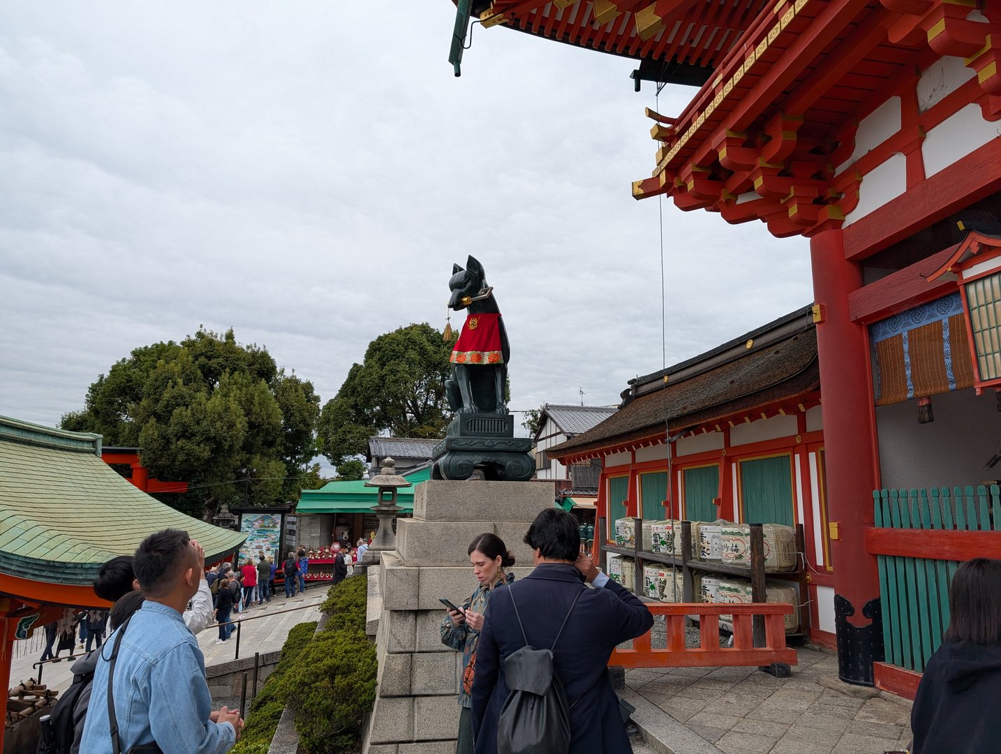 chuck and ashley checking out the iconic fox statues at fushimi inari shrine in kyoto. these guardian kitsune are EVERYWHERE here.