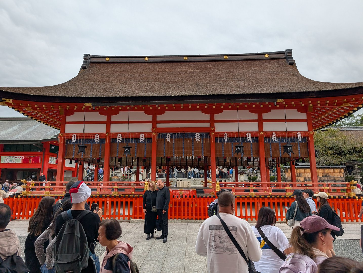 chuck and ashley joining the crowd at fushimi inari's main hall on a cloudy kyoto morning