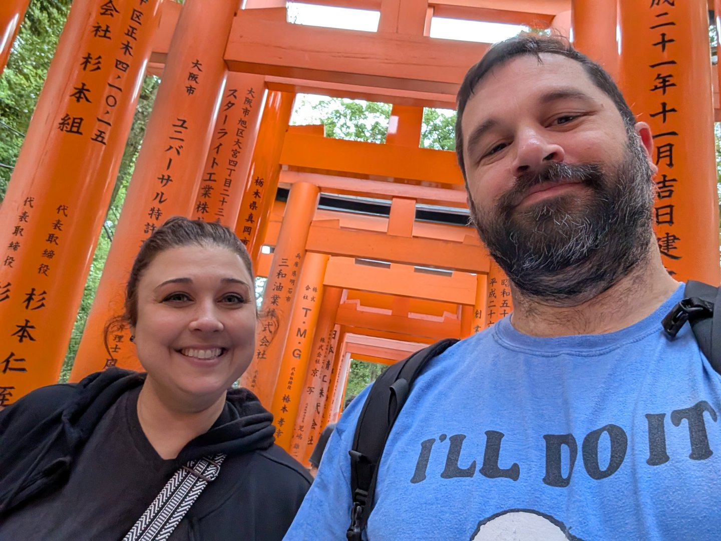 chuck and ashley taking a quick selfie under the ICONIC orange torii gates at fushimi inari shrine. those kanji characters behind them? each gate was donated by a japanese business