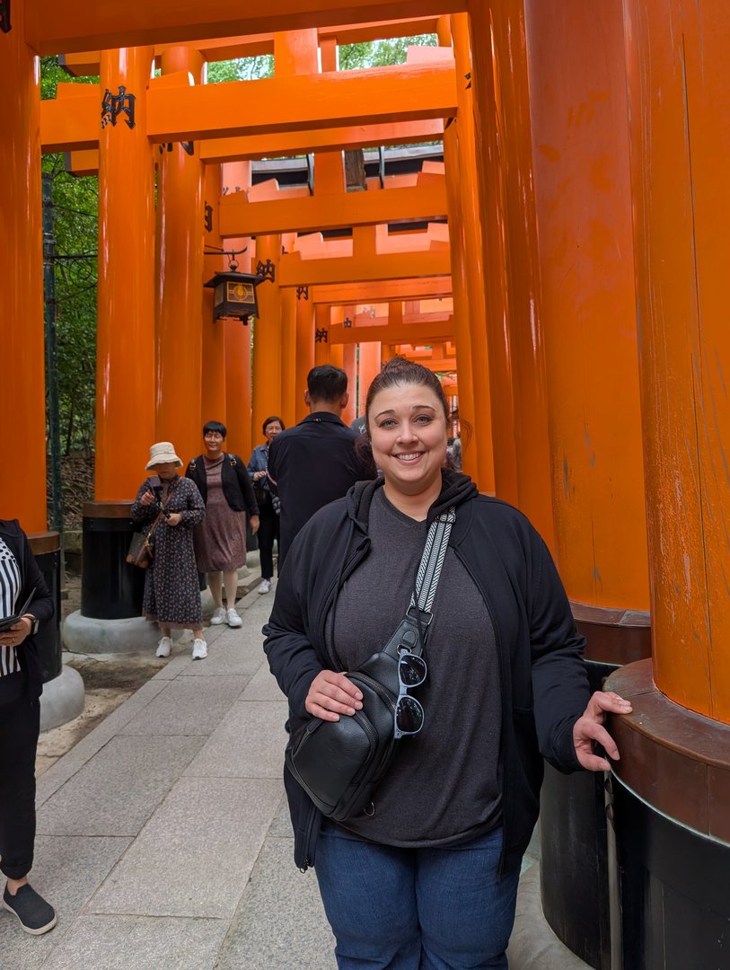 ashley taking a quick break under the ICONIC orange torii gates at fushimi inari shrine while chuck figures out how many more steps to the top