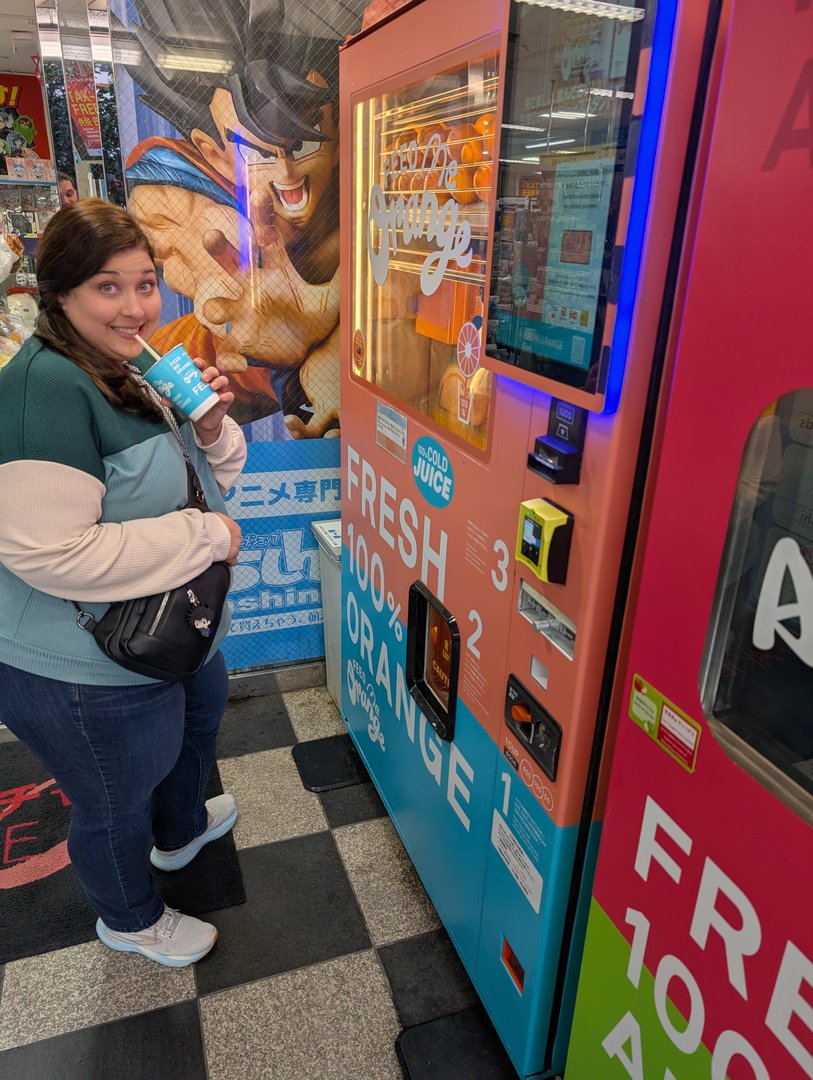 ashley trying out one of akihabara's MANY vending machines with dragon ball art in the background - these things are everywhere in japan