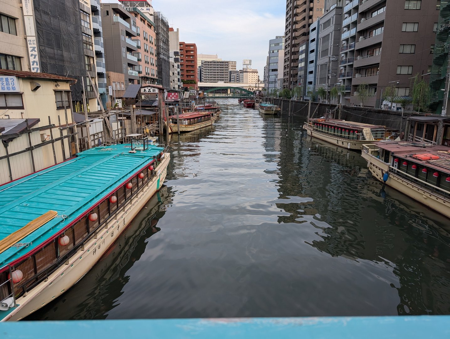 chuck caught this view of the traditional yakatabune boats lined up along the sumida river near asakusabashi. these old-school party boats are still a big deal here.