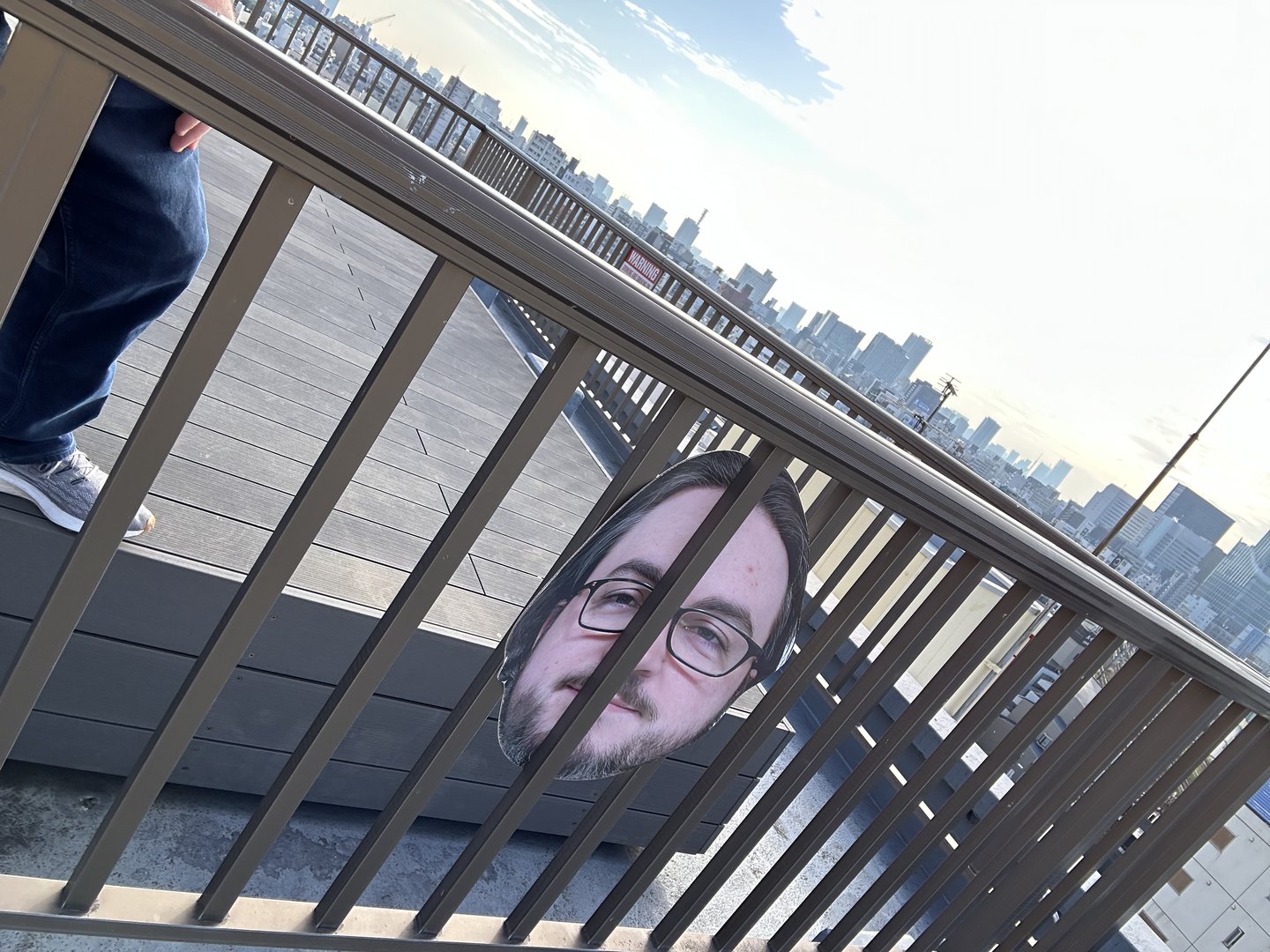 early morning view of the tokyo skyline from the observation deck at hundred stay hotel in shinjuku. dan doing his best impression of a jailed tourist.