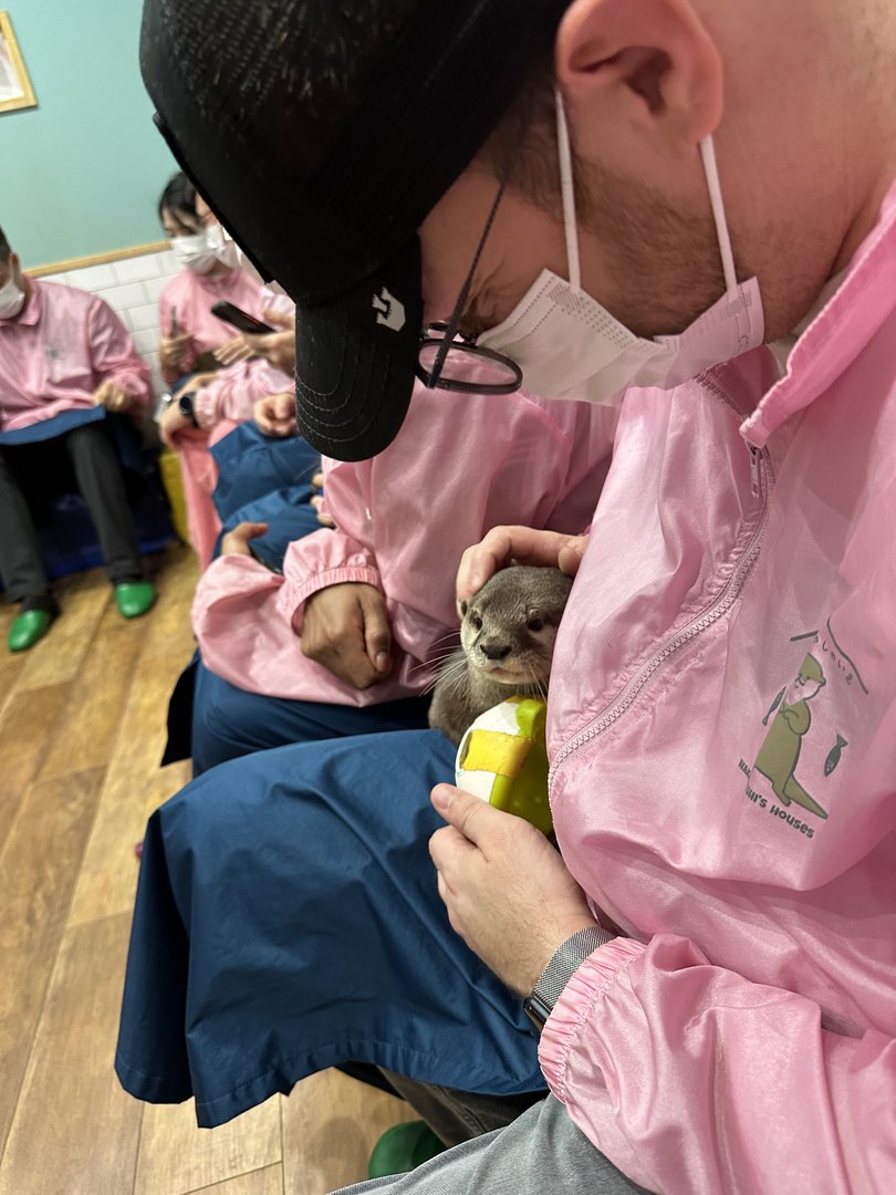 dan and christina getting their otter fix at harry harajuku, where you wear pink coveralls and hang with ACTUAL OTTERS (yes, really)