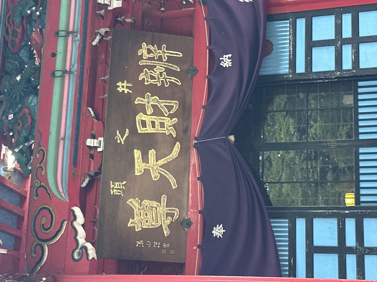 close-up of traditional kanji signage at what looks like a temple entrance - these gold characters against dark wood are CLASSIC japanese temple aesthetics