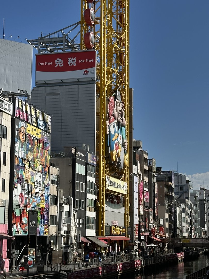 morning walk through dotonbori with dan behind the camera - this giant yellow crane with the kuidaore taro mascot is basically osaka's eiffel tower