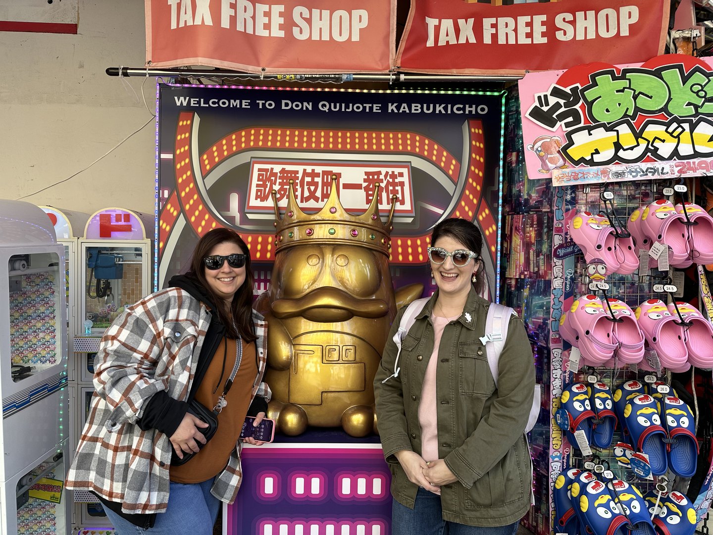 christina and ashley posing with the iconic golden duck mascot at don quijote in kabukicho. tax-free shopping = DANGER for our wallets