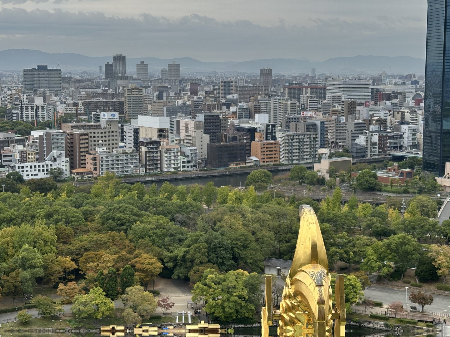 view from osaka castle's observation deck showing the MASSIVE golden shachihoko fish and the city sprawl beyond. dan got here early to beat the crowds.